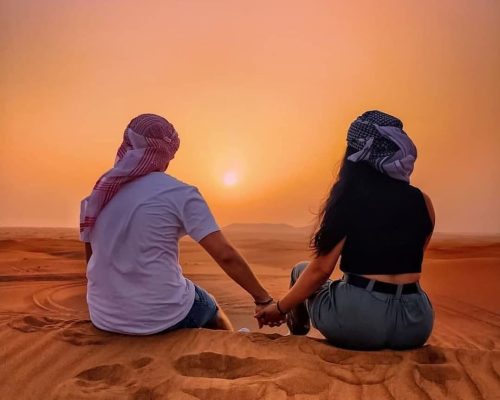 couple enjoying sunset in desert safari